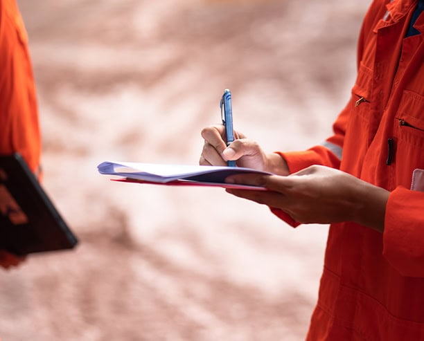 Oilfield Worker Writing Safety Inspection Report